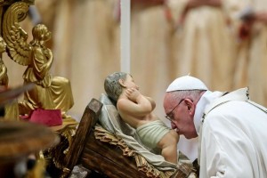 Pope Francis kisses a baby Jesus statue as he leads the midnight Christmas Mass in Saint Peters Basilica at the Vatican late 24 December 2015. ANSA/ALESSANDRO DI MEO
